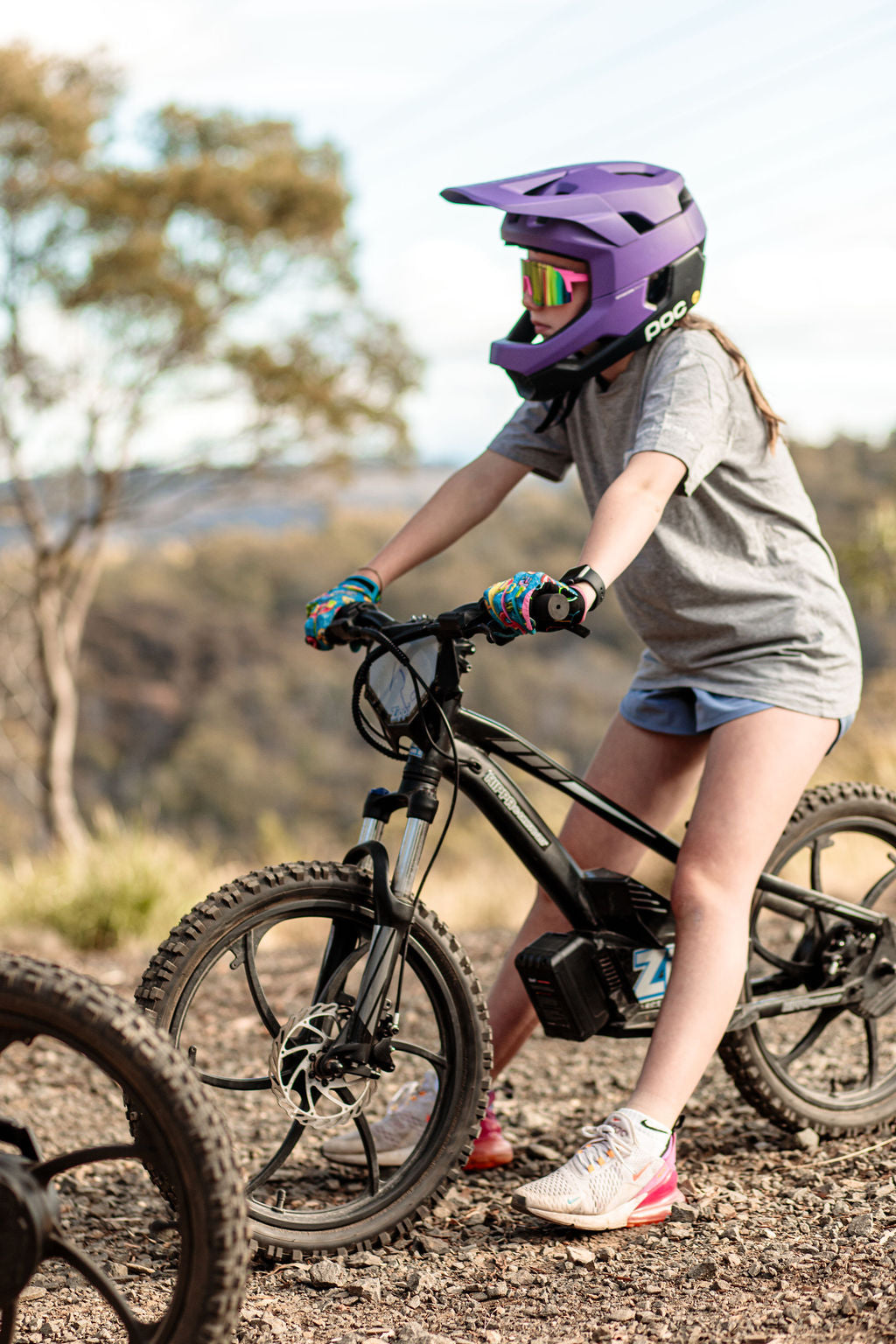 girl with helmet on sitting on balance bike