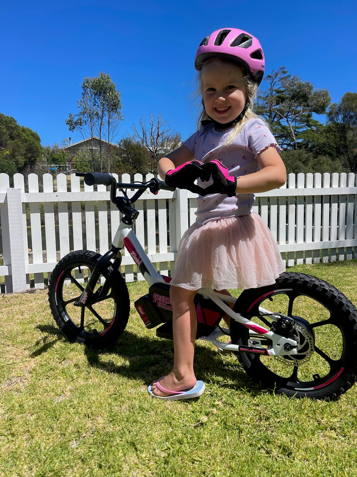 girl on zippi balance bike making love heart with hands