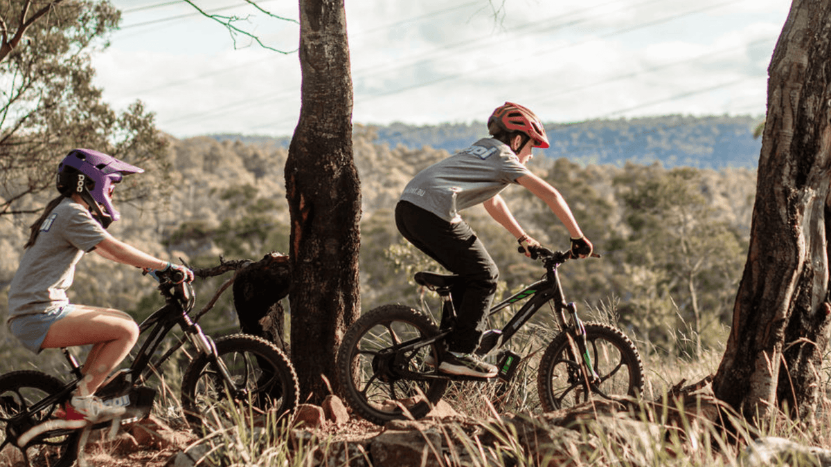 kids riding ebikes in bush setting
