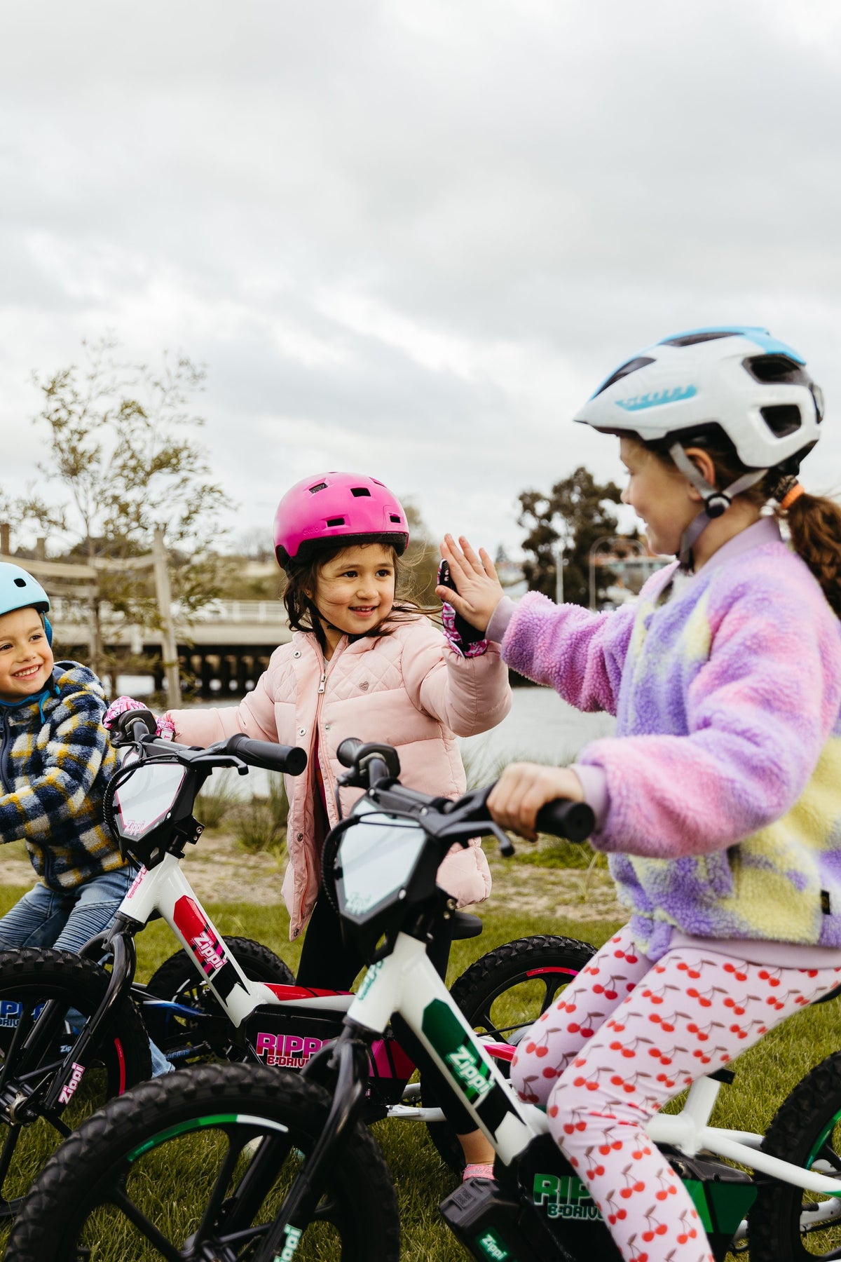 girls high fiving on rippa 16 bike